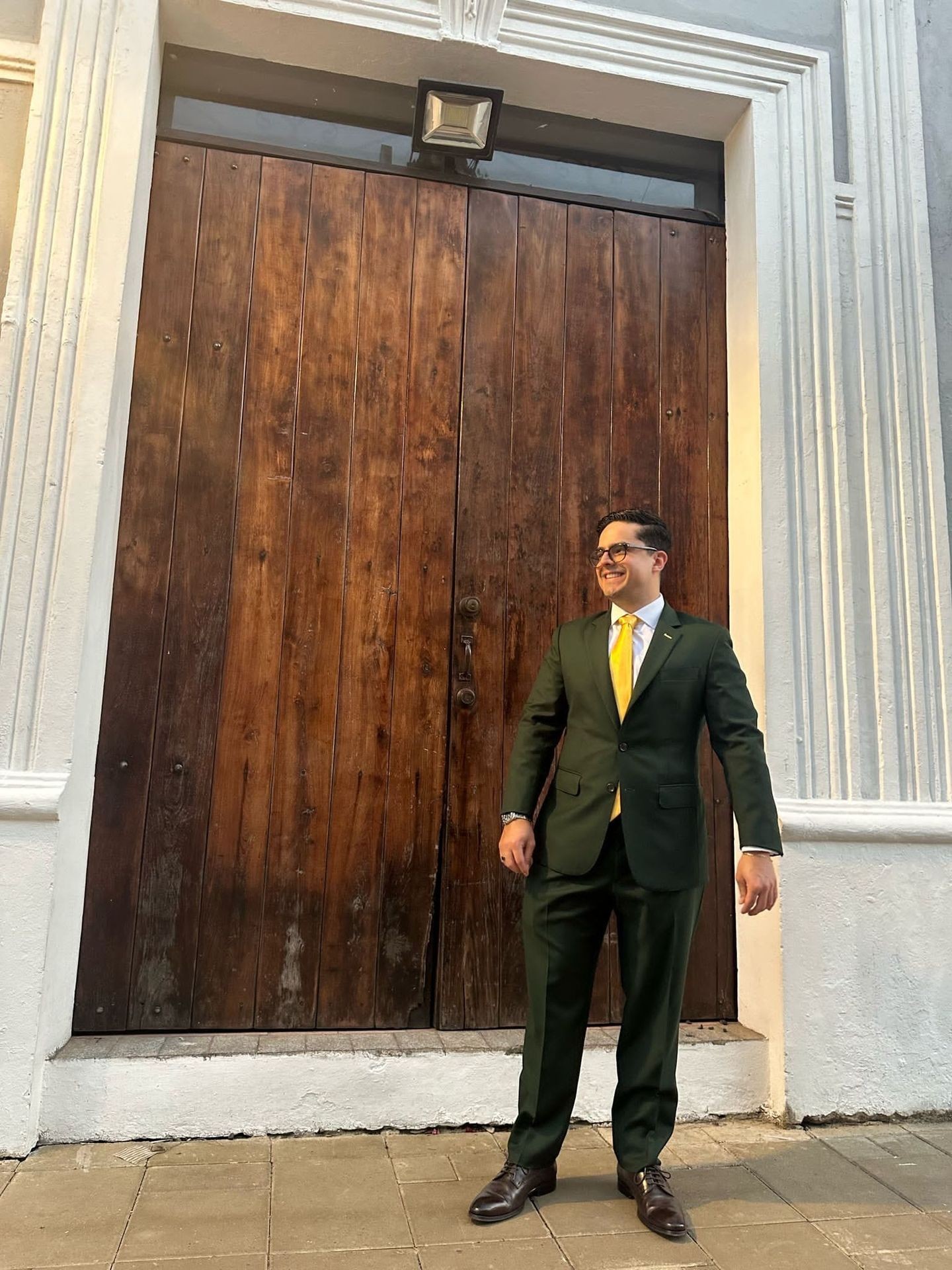 Kunde i skreddersydd mørkegrønn dress med gult slips fra Rashmi Custom Tailors Kunde i skreddersydd mørkegrønn dress med gult slips fra Rashmi Custom Tailors